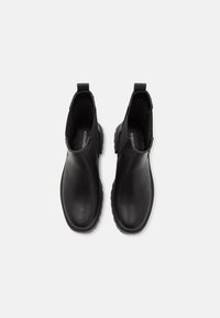 Black ankle boots made of smooth leather, with elastic side panels, pull tabs, and textured rubber soles for grip.