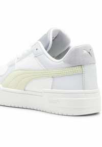 Fehér bőr sneaker, puha szürke velúrbakancs sarokkal, halvány zöld részlettel és texturált felülettel, lekerekített orral és lapos talppal.