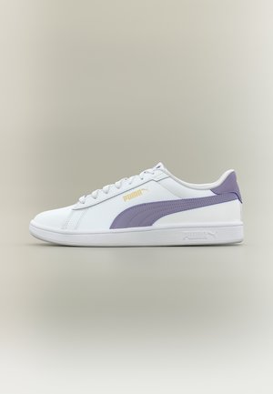 Balts Puma sporta apavu ar lavandas krāsas svītru un papēža cilpu, zelta Puma logotipu sānos, zemā tipa dizains ar baltiem aukliņām un gumijas zoli.