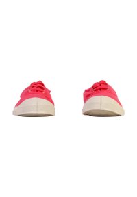 Une paire de baskets en toile rouges avec des semelles en caoutchouc blanches vues de l'avant sur un fond blanc.