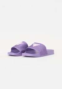 Infradito viola con una parte superiore in tessuto testurizzato e suola in gomma solida. Presenta un ampio design slip-on e un accento in logo triangolare.