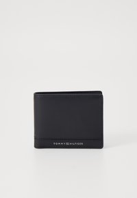 Czarny skórzany portfel o gładkiej powierzchni, w formacie bi-fold, z subtelnym przeszyciem. Na przedniej stronie znajduje się logo "TOMMY HILFIGER" w kolorze srebrnym.