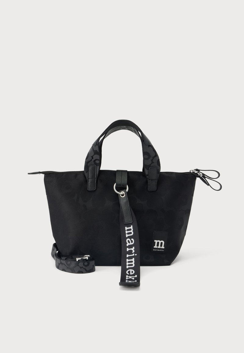 Μαύρη τσάντα tote Marimekko με κοντά χερούλια, αποσπώμενο ιμάντα, διακριτικό μοτίβο και ετικέτα υφάσματος με λογότυπο μπροστά.