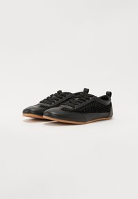 Schwarze Schuhe mit einer glatten Lederfront und Mesh-Seiten, runder Zehenform, Schnürdesign und einer hellbraunen Gummisohle.