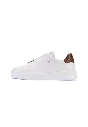 Zapatilla blanca de corte bajo con lengüeta trasera de cuero marrón y suela blanca gruesa, vista lateral.