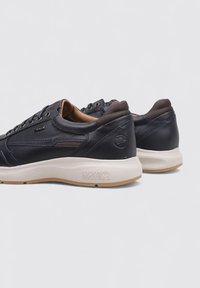 Zapatillas de cuero navy con acentos marrones, con un diseño de corte bajo, paneles texturizados y una suela de goma ligera con un logo.