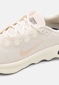 Lehká síťovaná teniska v jemně růžové barvě, s vlnitými detaily, kulatými očka a gumovou podrážkou s černým logem swoosh.