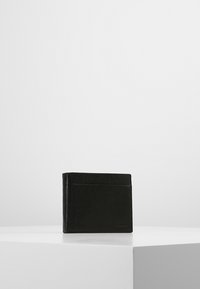Sort læderpung med glat tekstur, bi-fold design, der har en udvendig kortlomme og et diskret prægning af logoet foran.