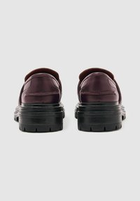 Burgundia värvi nahast kingad ümarate varvastega, tekstuuriga ülemise osa ja paksude mustade kummitaldadega, millel on mustrimuster.