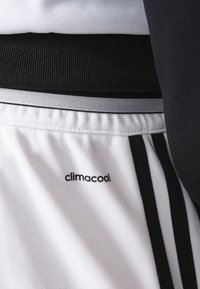 Vitaid shorts i vitt med svarta accenter, med en texturerad midja och "climacool"-logotyp på vänster ben.