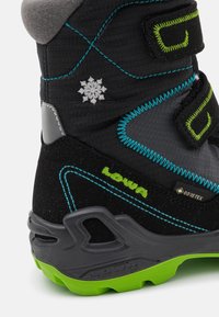 Stivaletto da trekking nero con accenti grigi, cuciture blu e dettagli verdi. Presenta l'etichetta GORE-TEX, un motivo a fiocco di neve e un design della suola robusto.