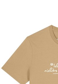 Beige T-Shirt mit kurzen Ärmeln und teilweise weißer deutscher Handschrift, die vorne mit "Ich" beginnt, vor schlichtem Hintergrund.