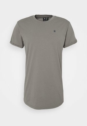 Prosta oliwkowo-zielona koszulka z krótkim rękawem i okrągłym dekoltem, z małym czarnym logo na lewej piersi oraz podwiniętymi mankietami rękawów.