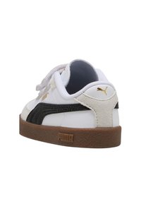 Sneaker bianco Puma con striscia nera, suola marrone, linguetta sul tallone in suede beige e logo Puma dorato sul tallone e sul lato, angolata dal retro.