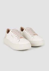 Sneaker in pelle bianca con dettagli rosa, punta rotonda, suola spessa e lacci coordinati. Presenta il nome del marchio in rilievo sulla linguetta.