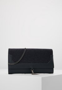 Svart kuvertväska med en texturerad övre del i svart glitter, slät svart botten, silverkedja och en tofsdetalj vid stängningen.