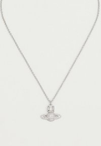 Collana a catena d'argento con un piccolo ciondolo a forma di pianeta con anelli, incrostato di pietre scintillanti trasparenti.