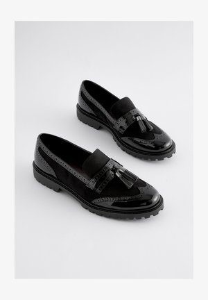 Fekete félcipők, fényes lakkbőr és velúr kombinációjával. Díszítésként bojtos rojtok, brogue mintázat és vastag talp található.