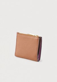 Small folded textured brown leather wallet with visible purple interior and gold zipper on white background.