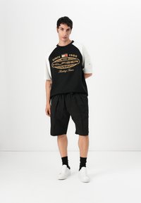 Tommy Hilfiger F1 MOVIE GRAPHIC RINGER T-SHIRT - T-shirts med print - black/ecru