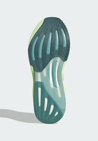 Zelená gumová podrážka tenisky s texturovanými vzory pro lepší přilnavost, transparentními akcenty a pevným pruhem. Lehký design s tlumícími drážkami.