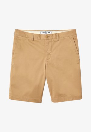 Shorts beige Lacoste coupe slim avec fermeture à bouton, passants pour ceinture et poches latérales, présentés à plat sur fond blanc.
