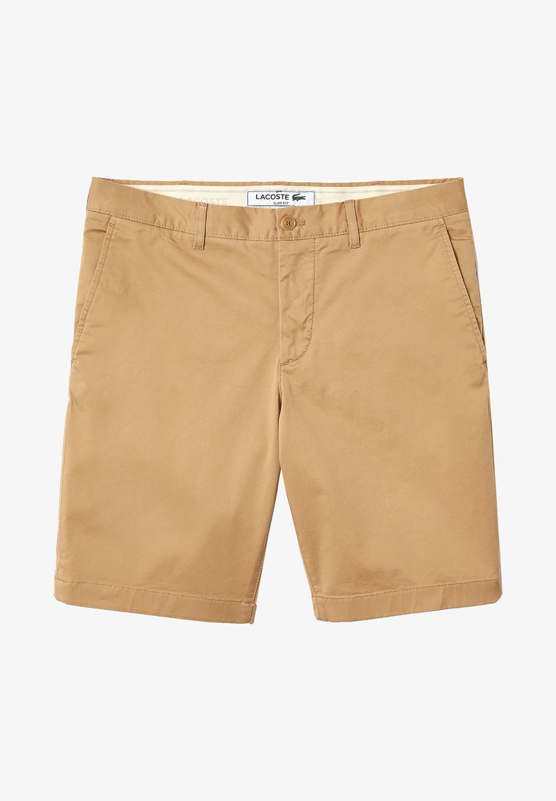 Shorts beige Lacoste coupe slim avec fermeture à bouton, passants pour ceinture et poches latérales, présentés à plat sur fond blanc.