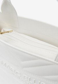 Borsa in ecopelle bianca con motivo a quadri diagonali, dotata di tasca interna con zip e hardware della zip in tono oro.