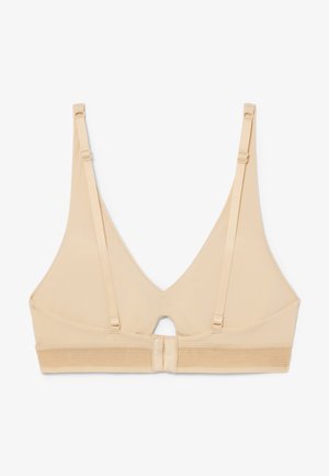 Beige draadloze beha met verstelbare bandjes en haak-en-oogsluiting, met een kleine sleutelgatuitsnijding midden op de rug.