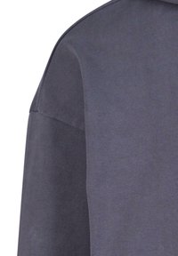 Felpa grigia scura con un design a coste testurizzato, con una finitura liscia nella parte superiore e un collo rotondo.