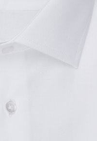 Witte kraagshirt van een gestructureerde stof, met een enkele knoopsluiting en gestikte details op de kraag en de sluiting.