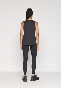 Top negro sin mangas y leggings a juego, hechos de tela suave; diseño ceñido al cuerpo con un aspecto limpio y aerodinámico.