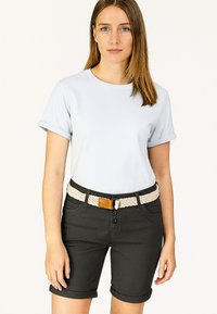 Light blue t-shirt with rolled sleeves paired with dark shorts. Shorts feature a braided belt with a tan accent, and three front buttons.