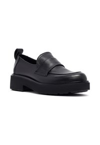 Zapatos negros de cuero tipo slip-on con una suela de plataforma resistente, que presentan una cinta ancha en el empeine y una lengüeta en la parte posterior para facilitar el uso.