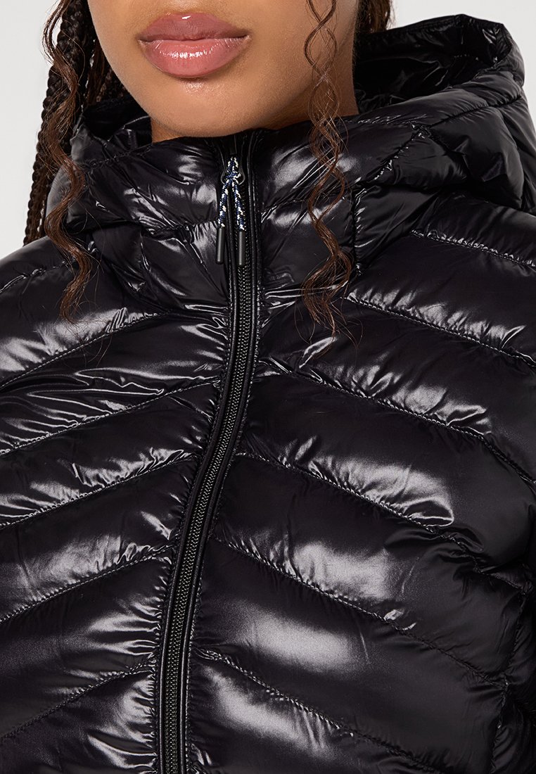 Czarna puchowa kurtka o błyszczącym, pikowanym wykończeniu. Charakteryzuje się wysokim kołnierzem, pełnym zapięciem na zamek błyskawiczny oraz teksturowanym wzorem w zygzaku na tkaninie.