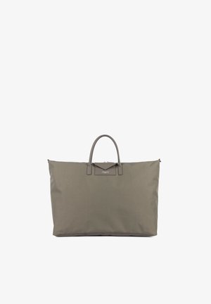 Duża torba typu tote w kolorze taupe z dwoma krótkimi uchwytami i małą przednią klapką z metką marki na jednolitym białym tle.