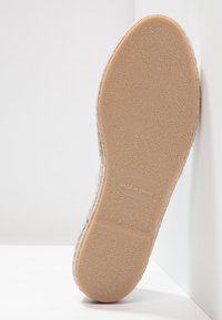Shoe sole with a textured surface, made of rubber, featuring a beige color and subtle patterns. Markings include "MADE IN SPAIN" and size 37.