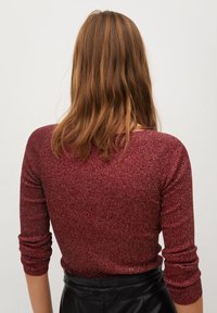 Pull bordeaux à côtes avec des manches trois-quarts, présentant une texture douce et des filaments métalliques, présenté de dos.