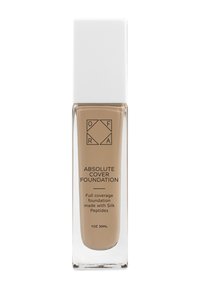 Ogenom transparent glasflaska med ett fyrkantigt vitt lock. Etiketten visar "Absolute Cover Foundation" i svart text, som framhäver full täckning och silkespolypeptider.