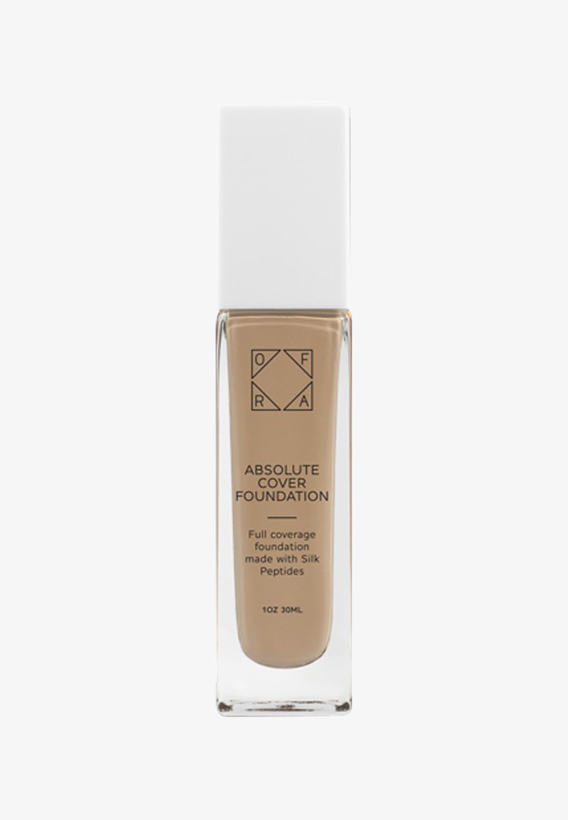 Ogenom transparent glasflaska med ett fyrkantigt vitt lock. Etiketten visar "Absolute Cover Foundation" i svart text, som framhäver full täckning och silkespolypeptider.