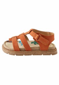 Orange mockasinsandaler med fyra breda remmar, justerbar spänne och en texturerad brun sula med prickiga detaljer.
