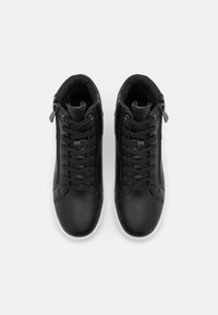 Zapatos negros de caña alta, hechos de piel suave, con cordones, un zipper lateral y suelas de goma blanca. Por dentro tienen un forro suave.