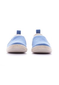 Zapatos slip-on azules con parte superior de lona, ribetes blancos y una suela texturizada beige. Cuentan con una pestaña en la parte posterior para ponerlos con facilidad.