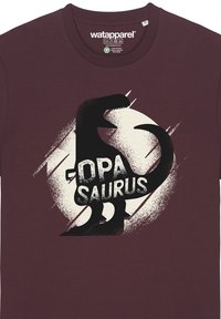 Bordeauxkleurig T-shirt met een zwarte dinosaurus-silhouet en de tekst "OPA SAURUS" in een sterke lettertype, tegen een gemêleerde crèmekleurige cirkel.