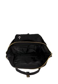 Sac en toile noir avec fermeture éclair dorée, intérieur spacieux, comporte plusieurs compartiments et un accent de logo sur le devant. Texture lisse.