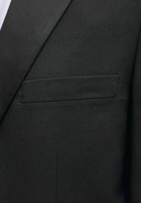 Suumise plaan mustast ülikonnajakist notšitud kraega ja vasakul küljel horisontaalse suletaskuga.