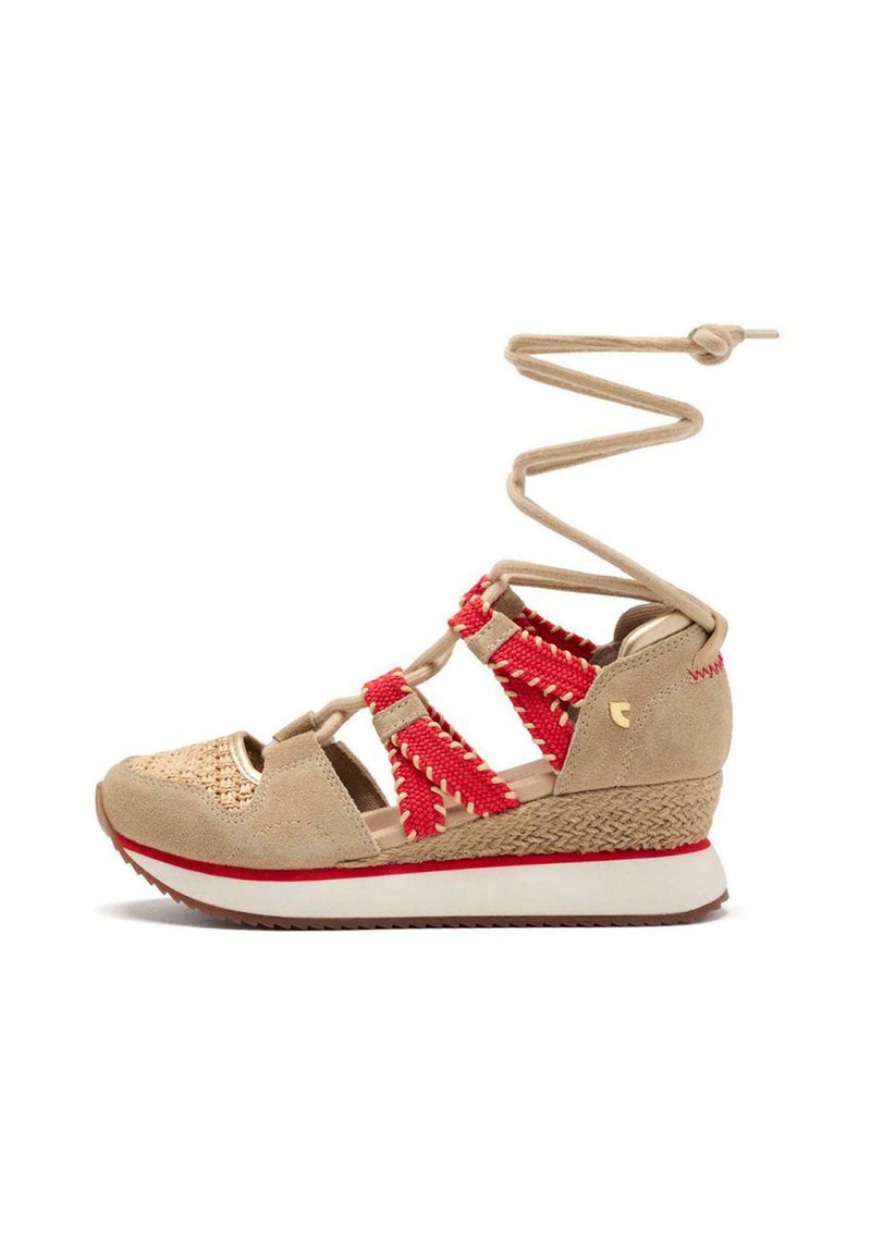 Sandalo con zeppa in suede beige, con dettagli intrecciati rossi, punta tonda, cinturini alla caviglia e una suola in zeppa testurizzata. Presenta una intersuola bianca e una suola in gomma.