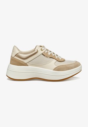Zapatilla beige con una mezcla de materiales de cuero, ante y malla. Cuenta con una suela blanca y detalles texturizados en la parte superior y la lengüeta.