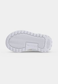 Semelle en caoutchouc blanche avec motif de bande de roulement en zigzag et crampons rectangulaires surélevés, arborant le logo Lacoste embossé au centre.