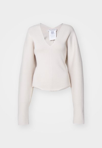 Balts ribots adīts džemperis ar dziļu V-veida kaklu un garām piedurknēm, ar īsu griezumu un neapstrādātu apakšmalu.